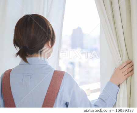 A housewife peering outside 10099353