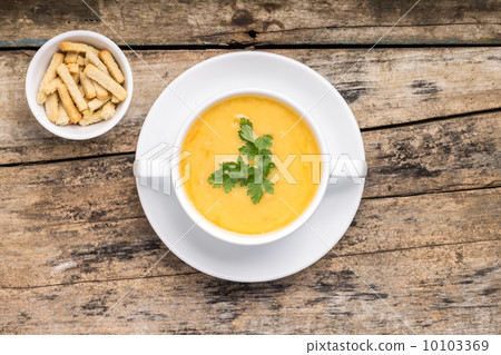 Pea soup with crotons on wood background Pea soup with crotons on wood background 10103369