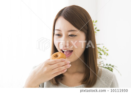 A woman eating a donut 10111930