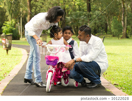 indian family teaching their kids cycling in the outdoor park 10122028