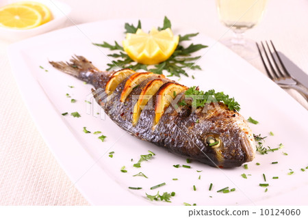 Grilled sea bream fish, lemon, arugula on white plate Grilled sea bream fish, lemon, arugula on white plate 10124060