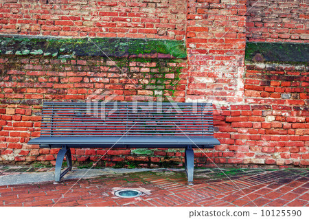 Metal bench and old brick wall in Alba, Italy. 10125590