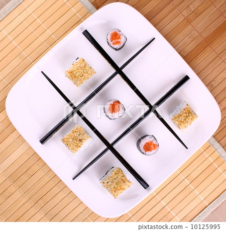 Tic tac toe play and chopsticks with sushi, close up 10125995