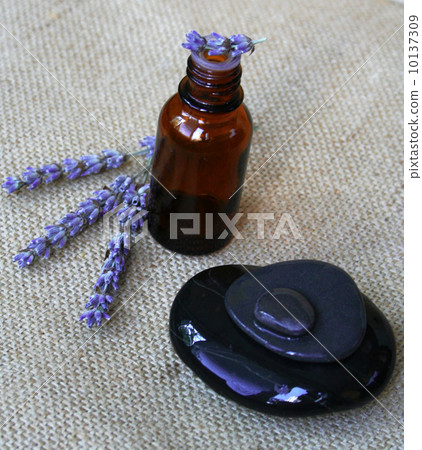 Lavender flowers and bottle of essential oil on sackcloth backgr Lavender flowers and bottle of essential oil on sackcloth backgr 10137309