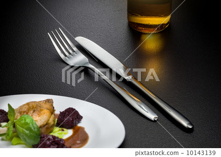 bottle of beer, knife and fork on table 10143139