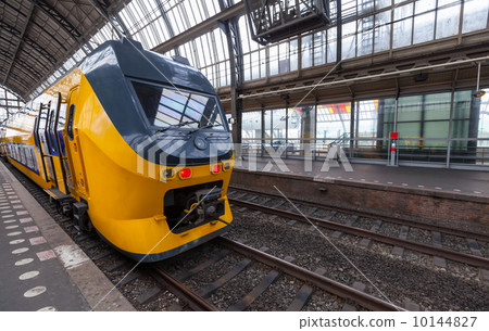 Yellow train stands on the central railroad station in Amsterdam Yellow train stands on the central railroad station in Amsterdam 10144827