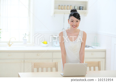A woman using a laptop in the kitchen 10151954
