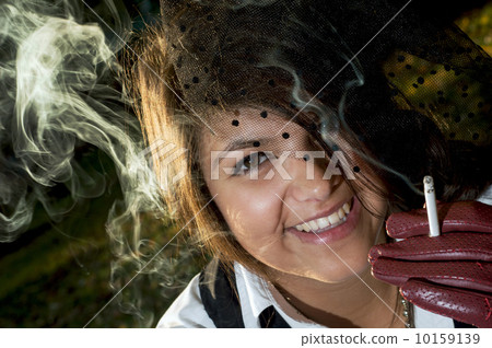 Young smiling woman smokes a cigarette Young smiling woman smokes a cigarette 10159139