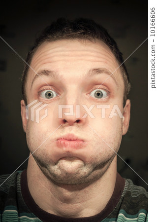 Young funny Caucasian man inflates cheeks. Closeup portrait 10166606