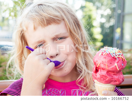 Little girl eats big fruit ice-cream in the park 10166752