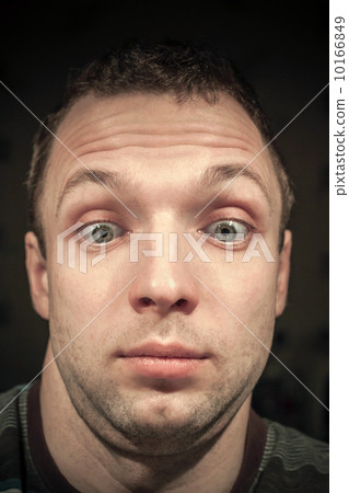 Shocked young Caucasian man portrait on dark background Shocked young Caucasian man portrait on dark background 10166849