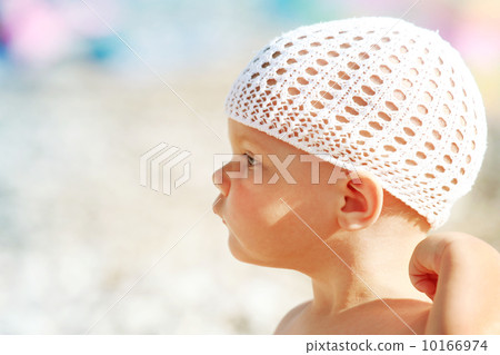 Outdoor summer profile portrait of curious Caucasian baby girl in white hat on the beach Outdoor summer profile portrait of curious Caucasian baby girl in white hat on the beach 10166974