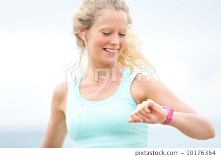 Running woman looking at heart rate monitor watch 10176364