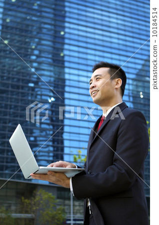 Asian businessman working outdoors with a laptop computer. Asian businessman working outdoors with a laptop computer. 10184514