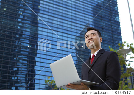 Asian businessman working outdoors with a laptop computer. Asian businessman working outdoors with a laptop computer. 10184517