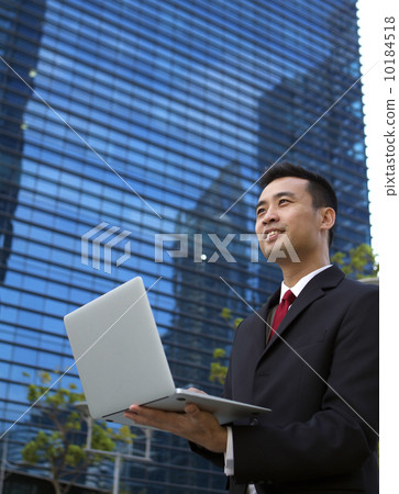 Asian businessman working outdoors with a laptop computer. Asian businessman working outdoors with a laptop computer. 10184518