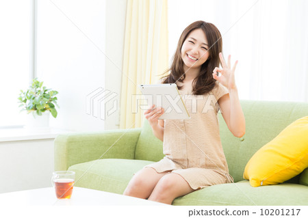 觀看一種片劑的婦女在屋子裡 觀看一種片劑的婦女在屋子裡 10201217