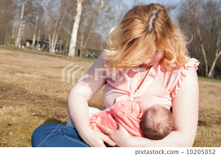 Mother is feeding her baby on the field Mother is feeding her baby on the field 10205852