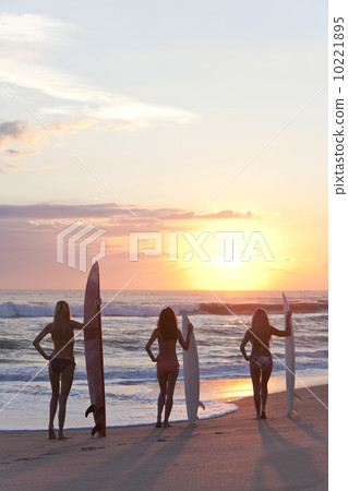 Woman Surfers In Bikinis With Surfboard At Sunset Beach 10221895