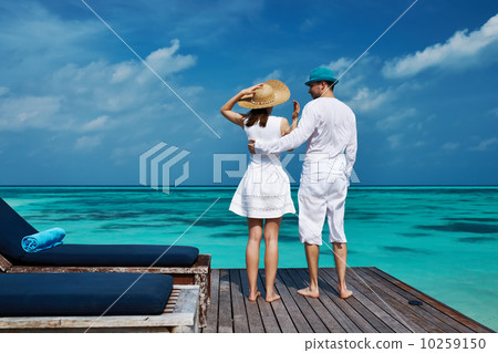 Couple on a beach jetty at Maldives Couple on a beach jetty at Maldives 10259150