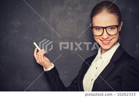 business woman teacher with glasses and a suit with chalk at a business woman teacher with glasses and a suit with chalk at a 10262333