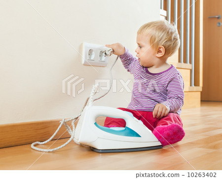 Toddler playing with electric iron Toddler playing with electric iron 10263402