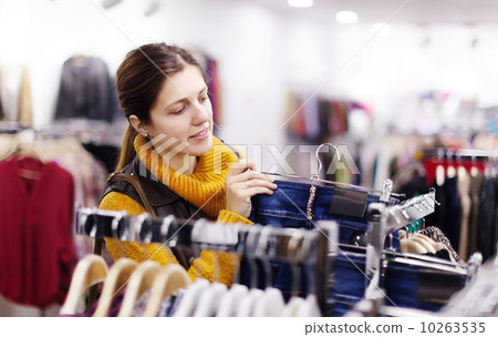Woman choosing jeans at  shop 10263535