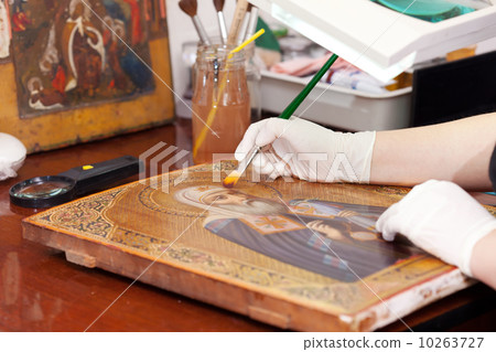 restorer works on old gilded icon with brush 10263727
