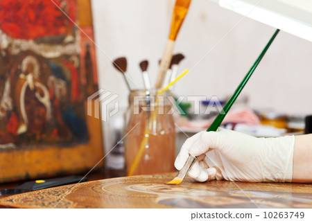 Artist works on icon with brush 10263749