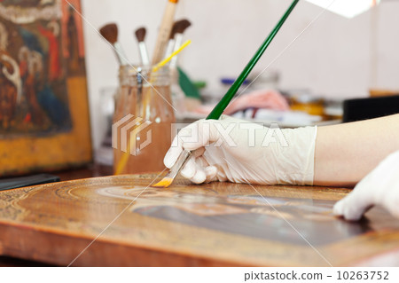 restorer works on ancient gilded icon 10263752