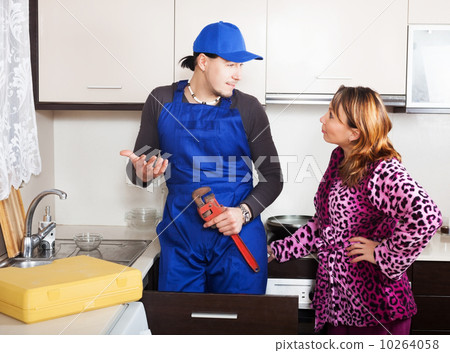 Housewife watching as man repairing Housewife watching as man repairing 10264058