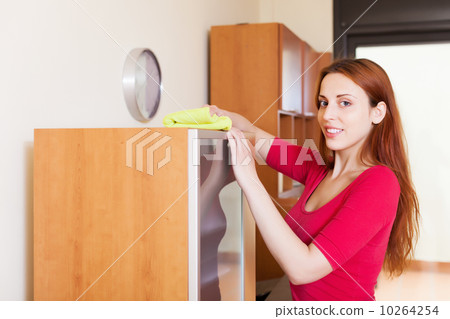 Smiling  woman dusting wooden furiture 10264254