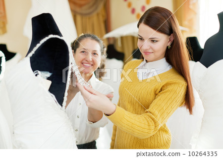 pretty bride chooses bridal outfit at shop of wedding fashion pretty bride chooses bridal outfit at shop of wedding fashion 10264335