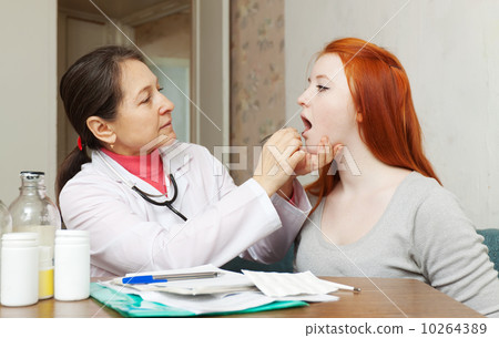 doctor looks throat of teenager doctor looks throat of teenager 10264389