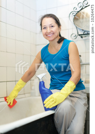 Smiling mature woman cleans bathroom Smiling mature woman cleans bathroom 10264475