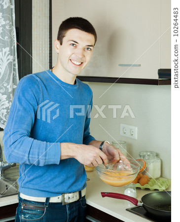 Guy pouring dough  in frying pan 10264483