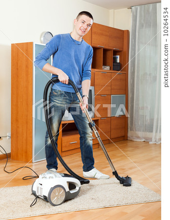 Ordinary guy with vacuum cleaner on parquet floor 10264534