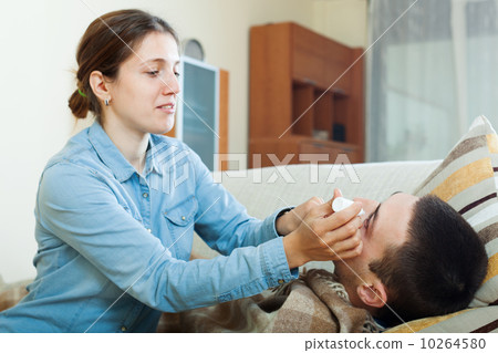 Caring woman dripping collyrium to husband 10264580