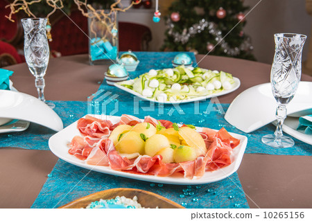 Holiday-decorated table, Christmas tree, ham and melone, and sal 10265156