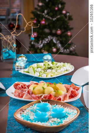 Holiday-decorated table, Christmas tree, ham and melone, and sal 10265166
