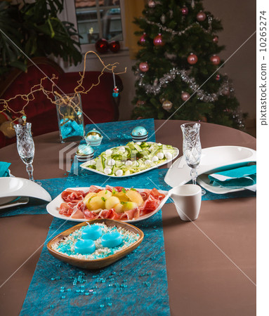 Holiday-decorated table, Christmas tree, ham and melone, and sal 10265274