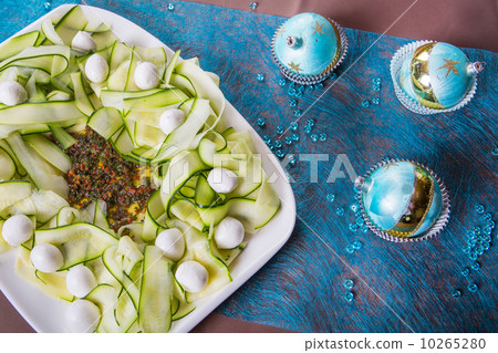 Holiday-decorated table, Christmas toys and zucchini salad. 10265280