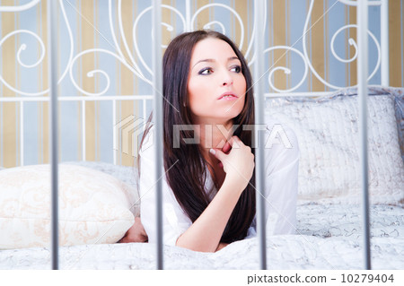 Portrait of brunette woman on the bed. 10279404