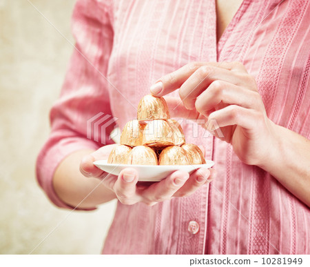 Young woman holding a chocolate candies Young woman holding a chocolate candies 10281949