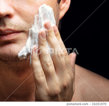 Young man applying a shaving foam 10281970