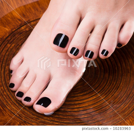 Beautiful women legs with black pedicure after Spa procedures 10283963
