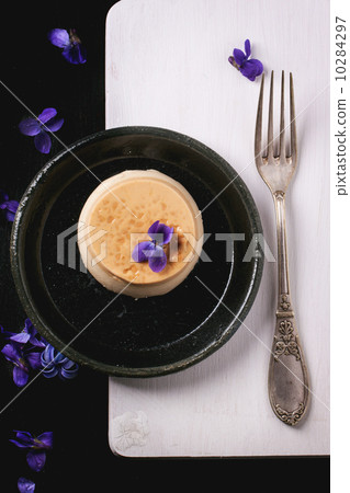 Caramel pannacotta with violet flowers 10284297