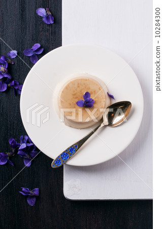 Caramel pannacotta with violet flowers 10284300