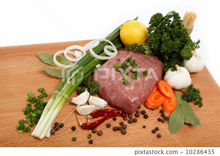 raw meat, vegetables and spices isolated on a wooden table. 10286435