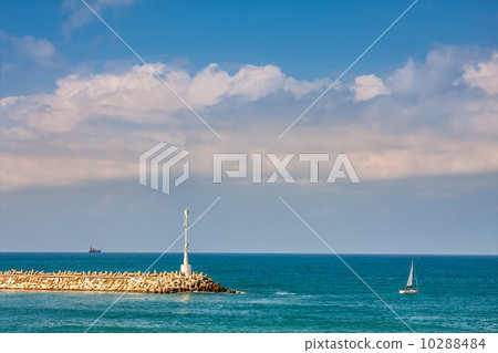 Breakwater with beacon and yacht on Mediterranean sea. 10288484